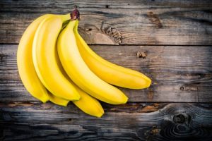 A bunch of bananas on a wooden background.