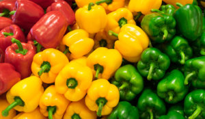 Red, yellow, and green bell peppers on display.