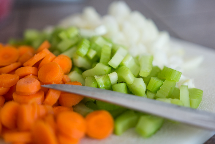 Carrots, onions, and celery diced with a knife.