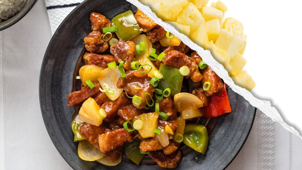 A dish of sweet and sour pork featuring raw pineapple. 