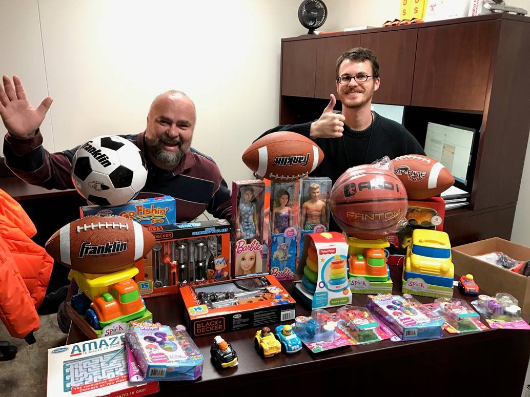 Russell Martinez and David Kaylor having fun with part of FreshPoint Dallas' toy donation to The Family Place.