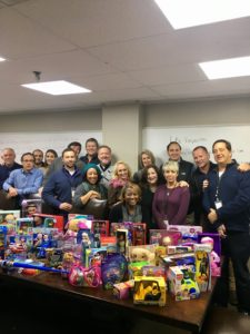 FreshPoint Dallas' retail team having fun with their train display of 99 toys donated to The Family Place.