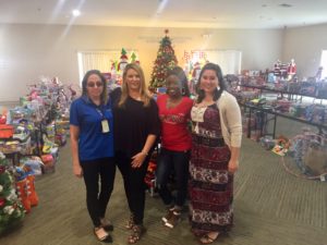 Jennifer Walls, Kelly Walsh, Jane Watson & Cindy Brunetto in front of the many donations from the community to benefit Women In Distress. They are displayed so the families may go "shopping.”
